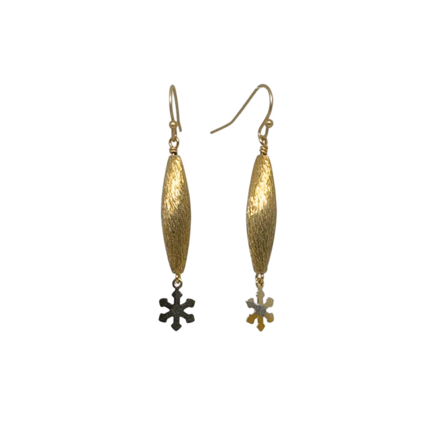 Close-up view of gold textured pod earrings with a small snowflake charm dangling below, showcasing their delicate and minimalist design.