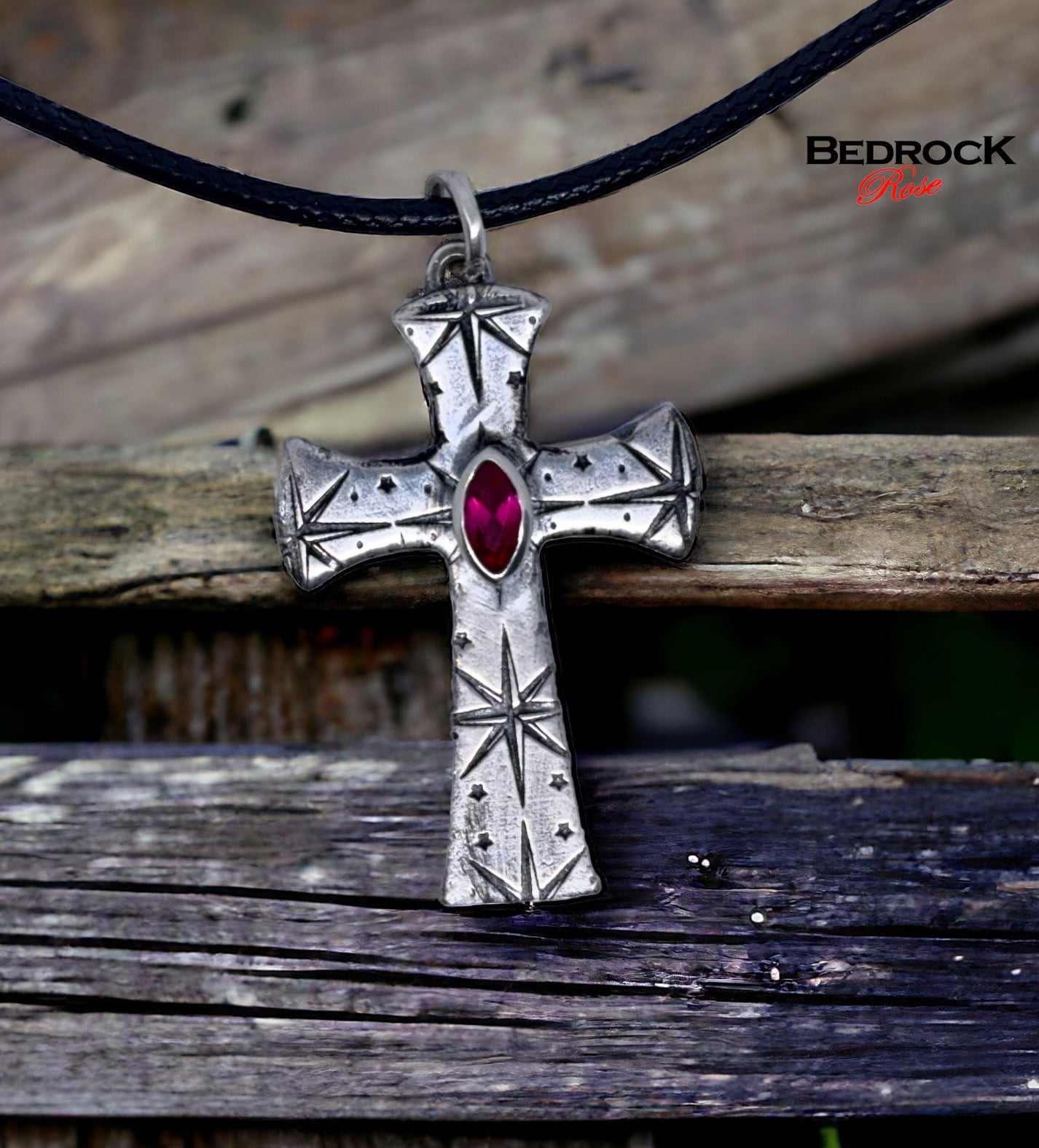 Front view of fine silver cross pendant with intricate pattern and ruby red marquise stone, handmade necklace