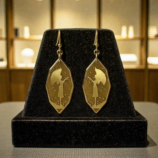 Bedrock Rose gold-tone metal earrings featuring a girl silhouette with umbrella and falling hearts. Elongated diamond shape.