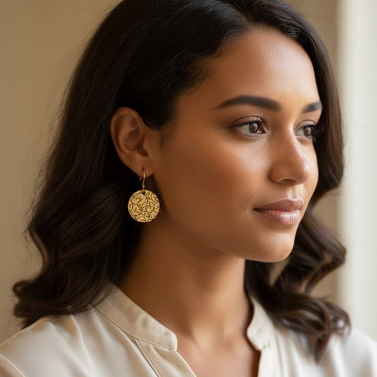 Bedrock Rose gold-tone disc earrings with all-over botanical vine lattice etching. Dangles hang from gold hooks.