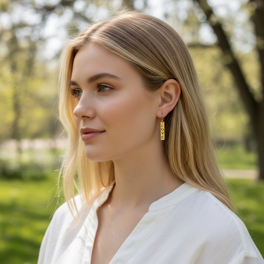 Bedrock Rose gold-plated dangling earrings with laser-cut "Love" text, surgical steel earwires.