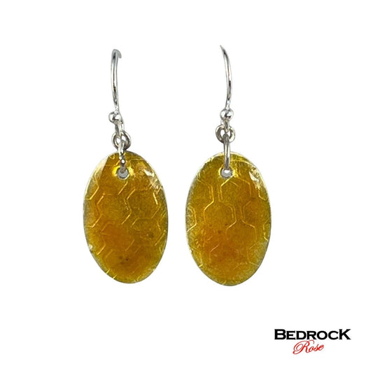 Bedrock Rose honey-colored oval earrings with honeycomb pattern, dangling from silver hooks.