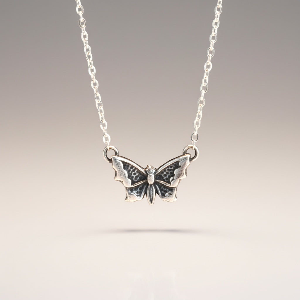 Bedrock Rose petite silver butterfly pendant necklace with intricate wing details.