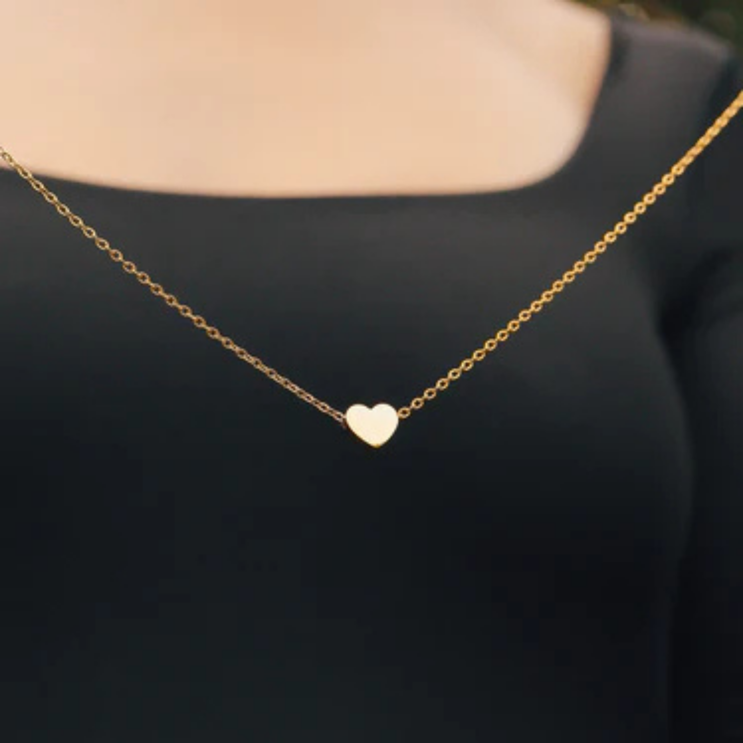 Gold heart-shaped necklace on a black background