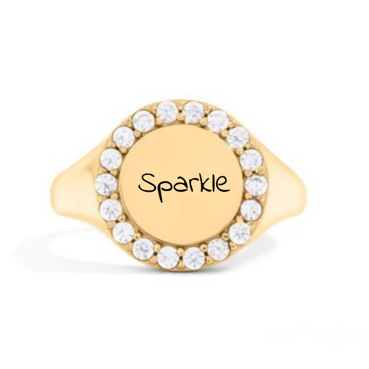 Gold ring with 'Sparkle' engraving and clear stones on a white background