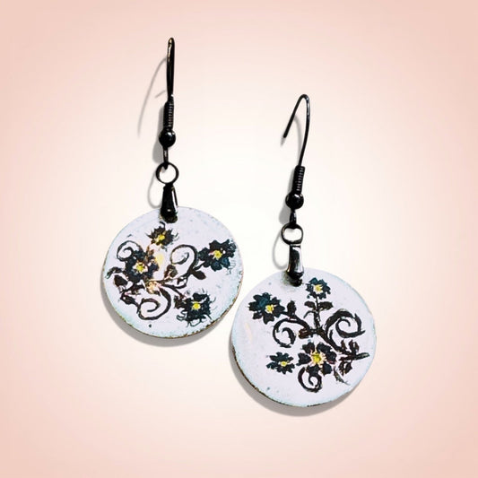 Pair of round earrings with floral design on a gradient background