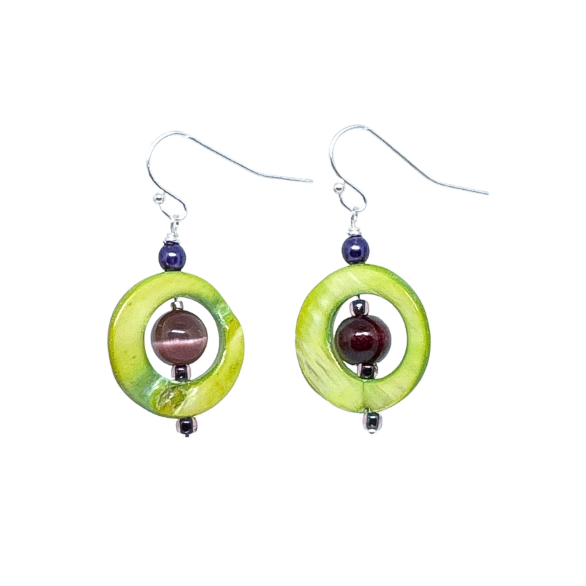 Close-up view of green shell and amethyst dangle earrings featuring circular shell pieces with natural variations and a purple amethyst bead in the center, showcasing their unique design.