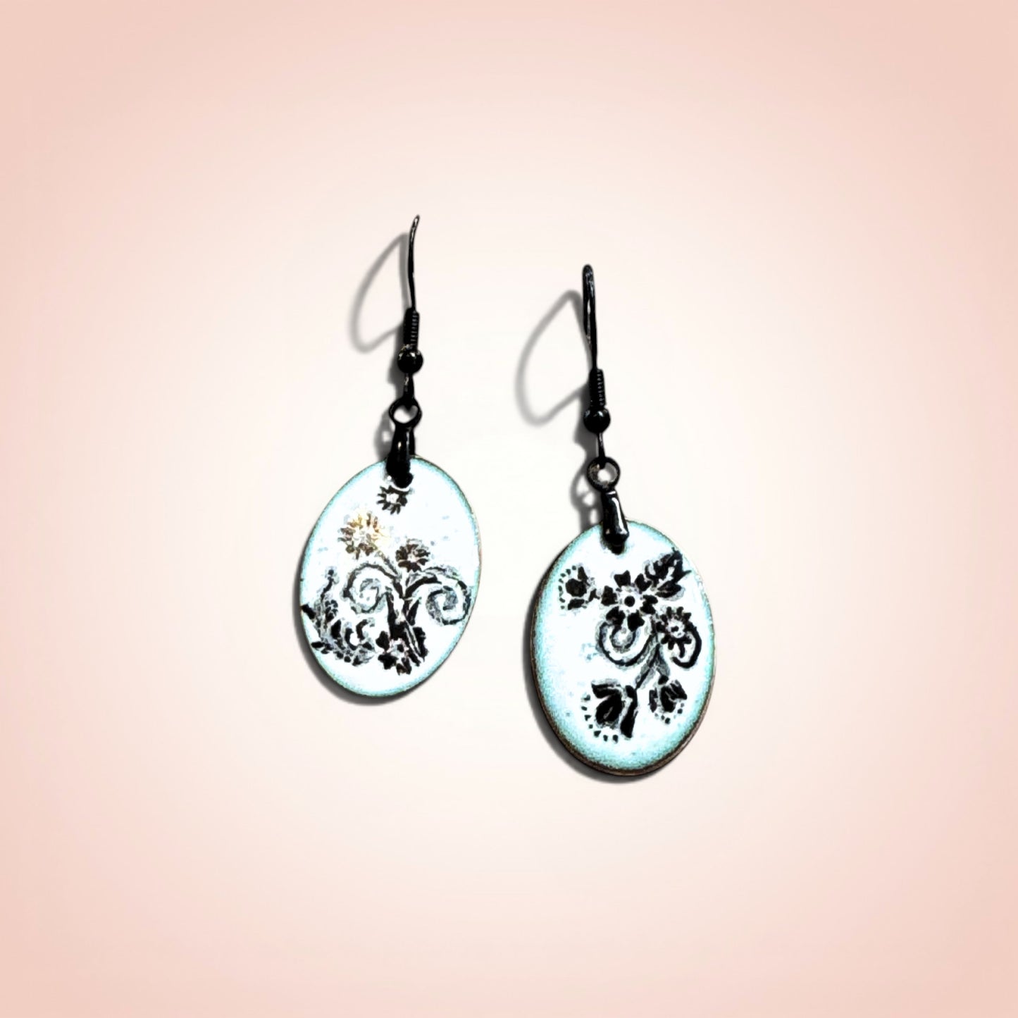 Pair of earrings with floral design on a gradient background