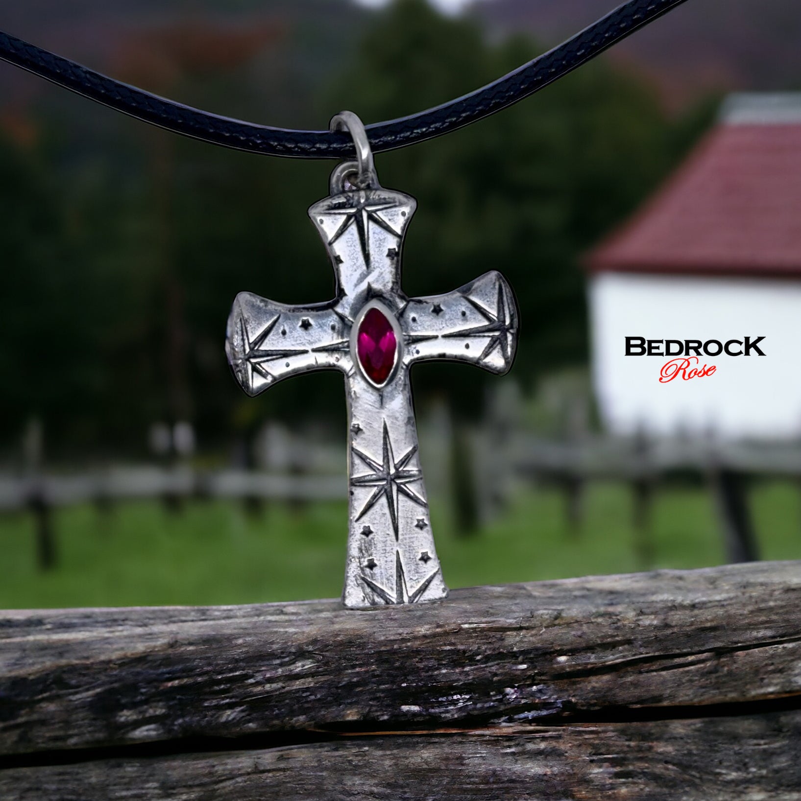 Front view of fine silver cross pendant with intricate pattern and ruby red marquise stone, handmade necklace