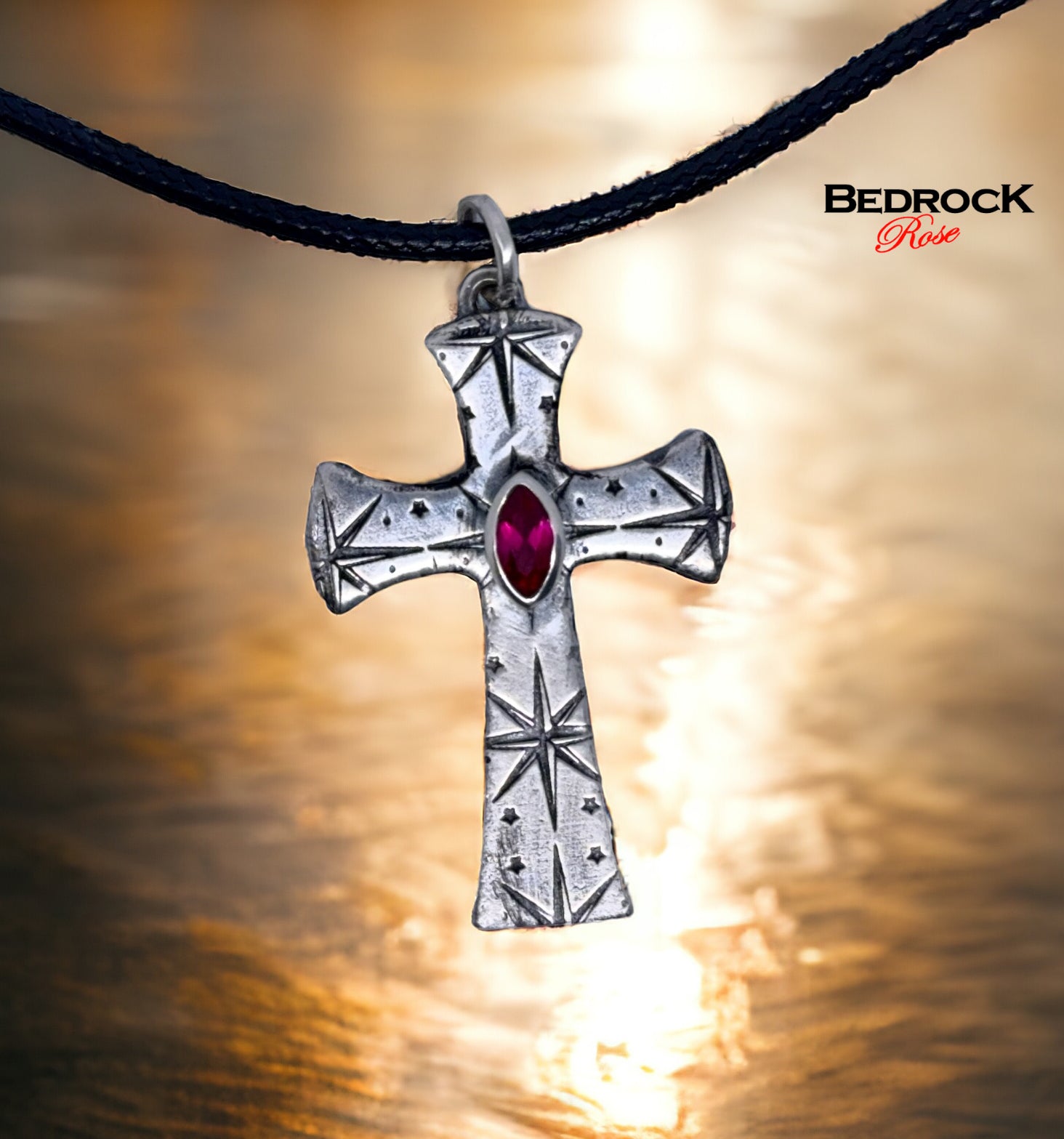 Front view of fine silver cross pendant with intricate pattern and ruby red marquise stone, handmade necklace