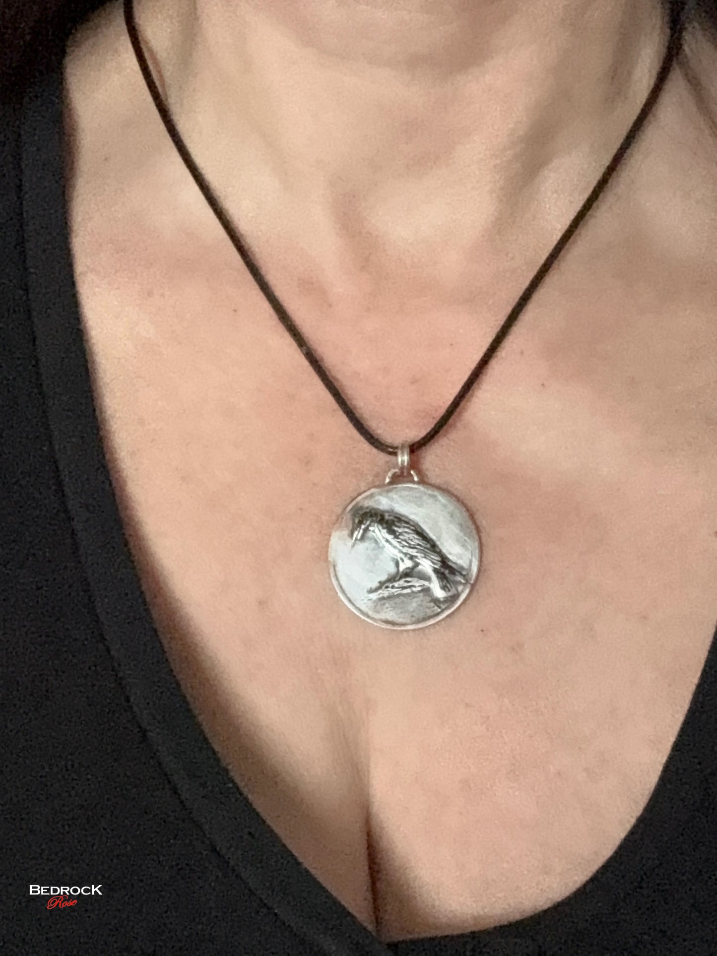 Close-up view of detailed crow design on the round silver pendant, Bird Jewelry, Handmade Necklace