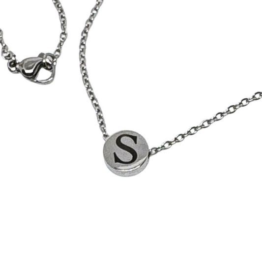 Close-up of a silver/gold stainless steel bead necklace featuring the initial S engraved on the bead