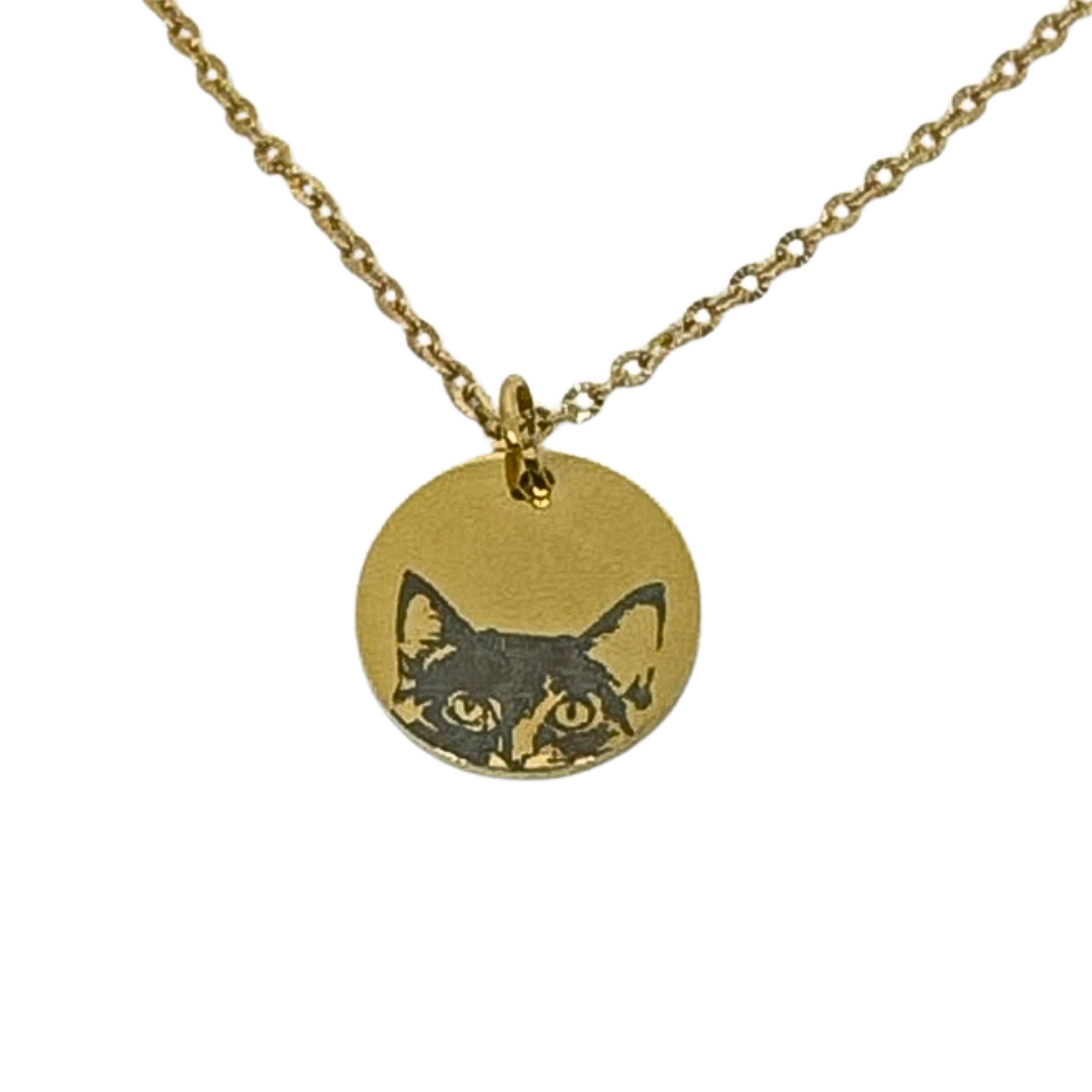 Close-up of a gold stainless steel necklace featuring a cat face design laser engraved on a round pendant, showing the cat peeking over the edge