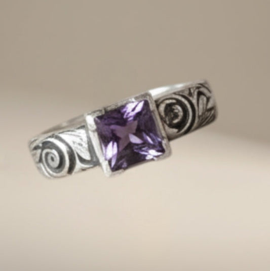 Bedrock Rose sterling silver ring with square amethyst-colored stone and floral engraving. Size 8 3/4.