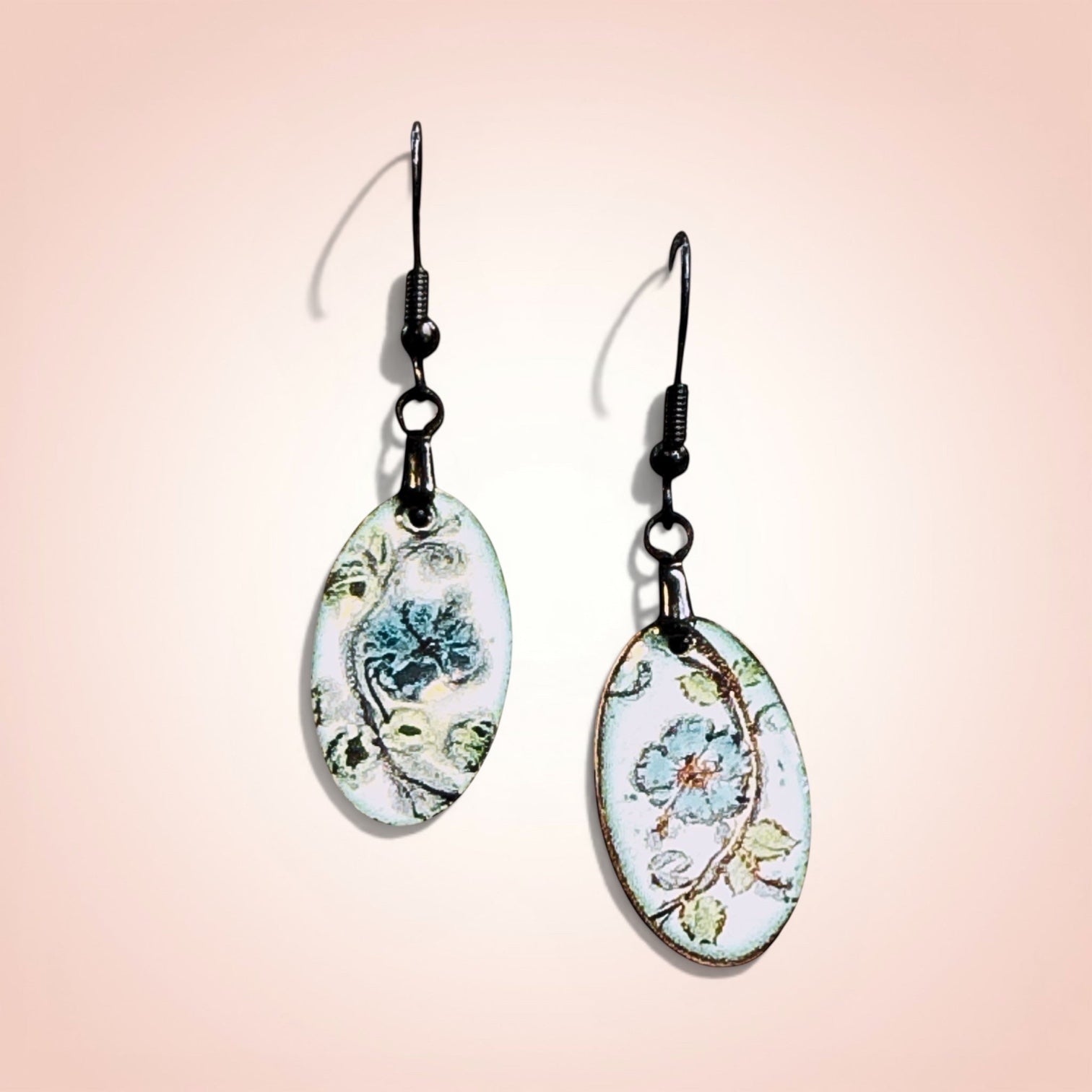 Bedrock Rose hand-painted oval earrings with azure blue flowers and green leaves on white enamel.