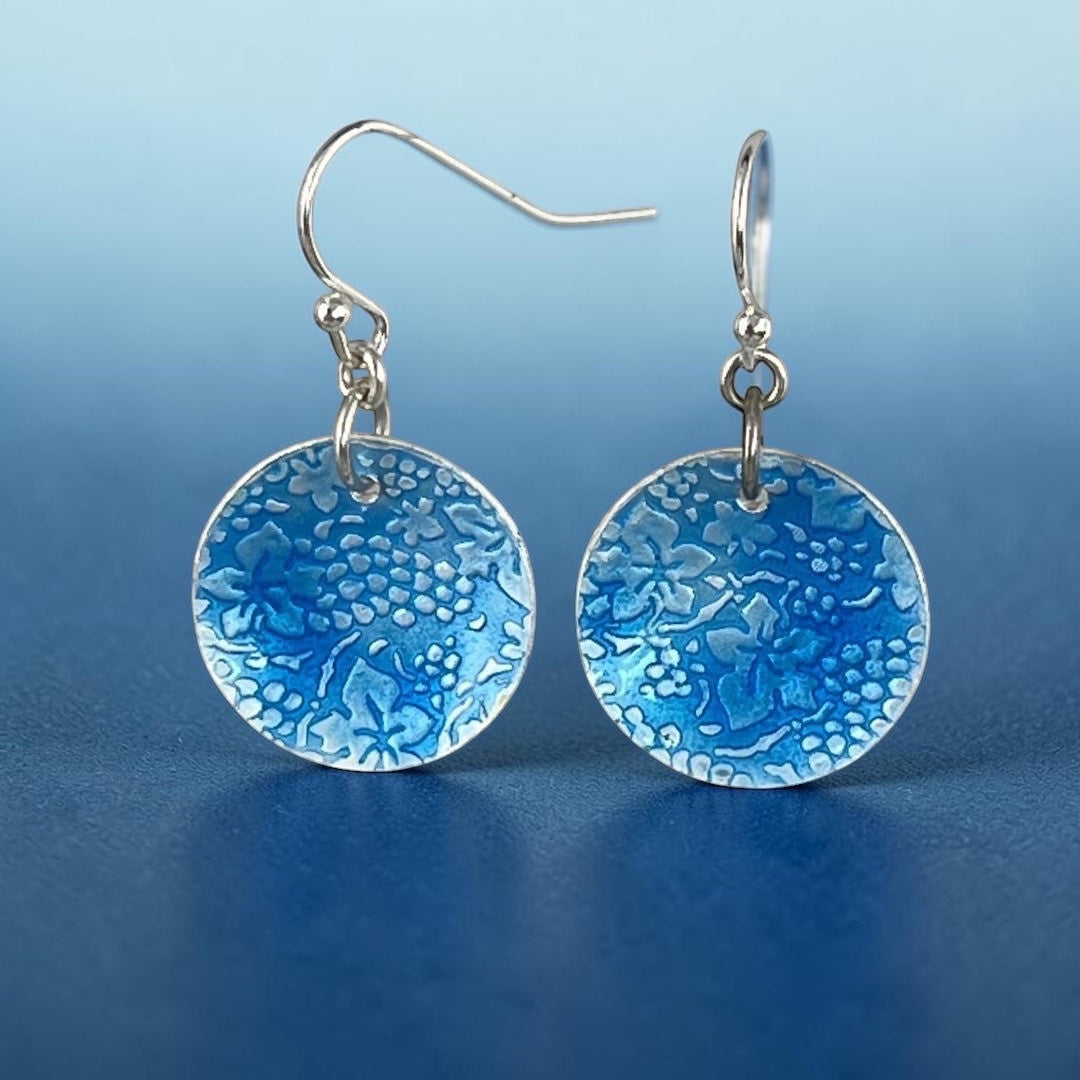 Bedrock Rose circular dangle earrings featuring a roll-printed grape and leaf motif in cobalt blue vitreous enamel.