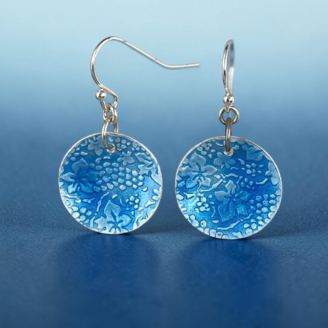 Bedrock Rose circular dangle earrings featuring a roll-printed grape and leaf motif in cobalt blue vitreous enamel.
