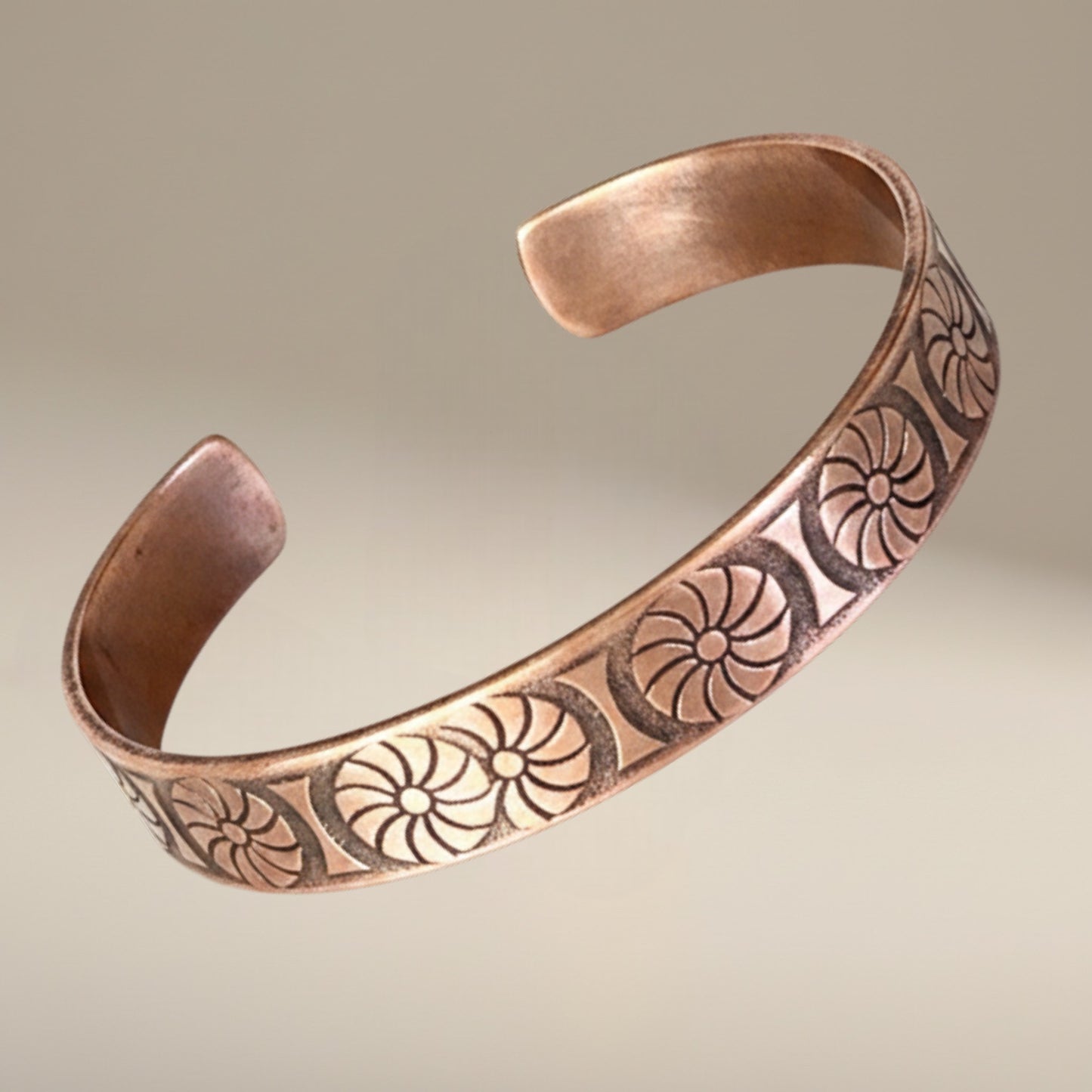 Bedrock Rose handcrafted copper cuff bracelet featuring an antique floral sunburst pattern with a dark patina finish.