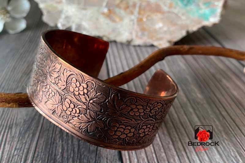 Bedrock Rose copper cuff bracelet featuring an intricate embossed grapevine pattern with a polished finish.