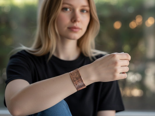 Bedrock Rose copper cuff bracelet featuring an intricate polished grapevine pattern worn on a woman's wrist