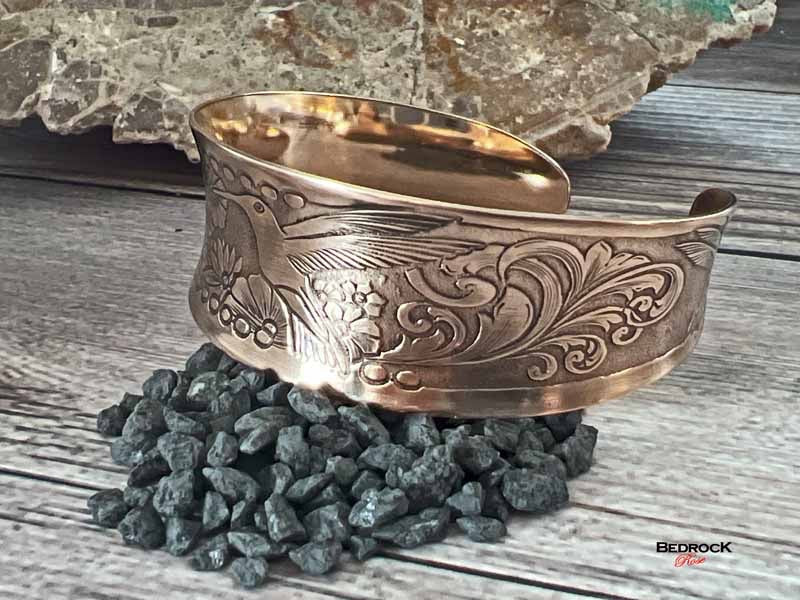 Bedrock Rose polished copper hummingbird cuff bracelet with intricate floral engraving and a concave design.