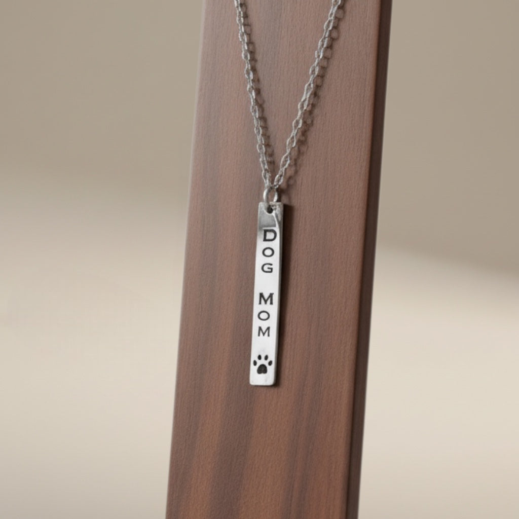 Bedrock Rose silver stainless steel vertical bar necklace engraved with DOG MOM and a paw print.