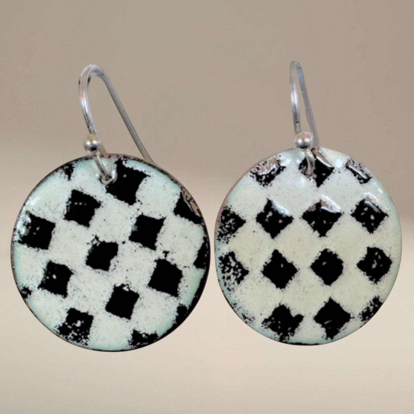 Bedrock Rose handmade round copper dangle earrings with a textured black and white kiln-fired enamel checkerboard.