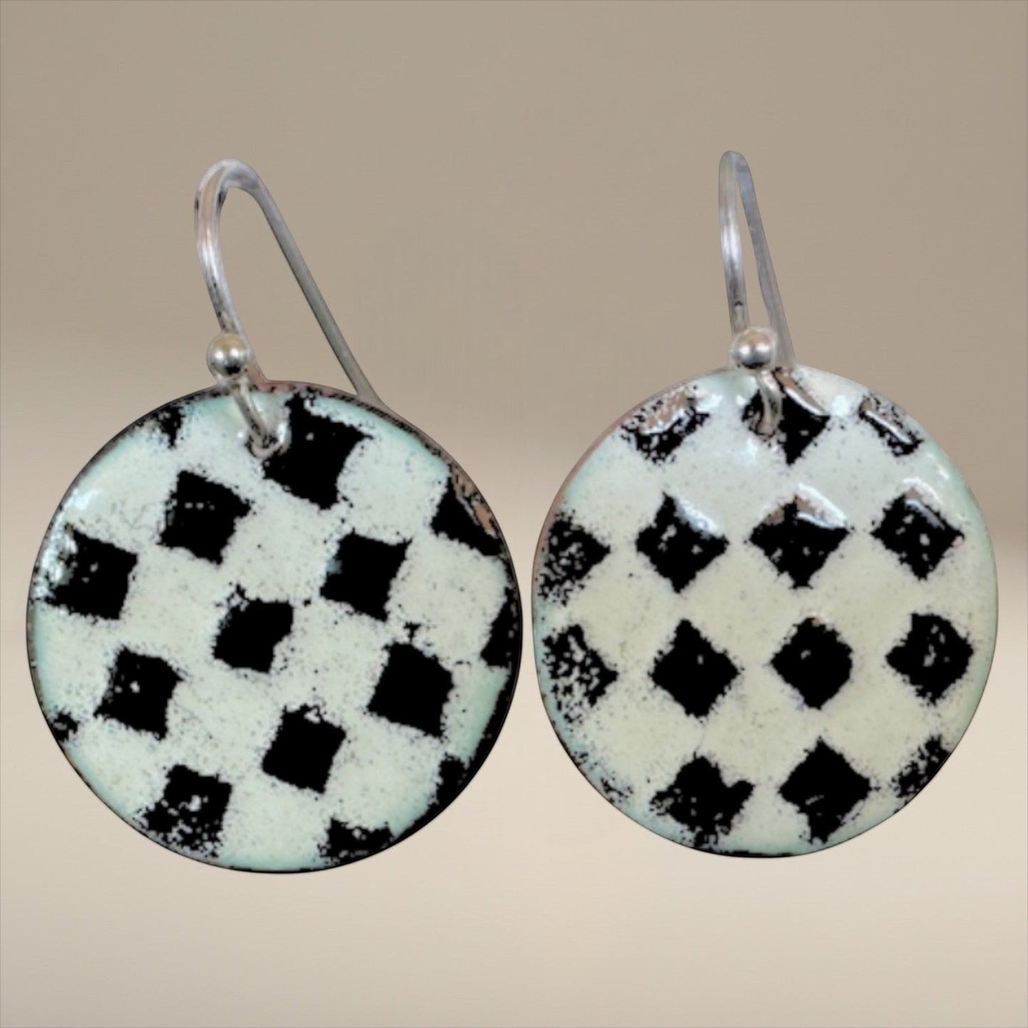 Bedrock Rose handmade round copper dangle earrings with a textured black and white kiln-fired enamel checkerboard.