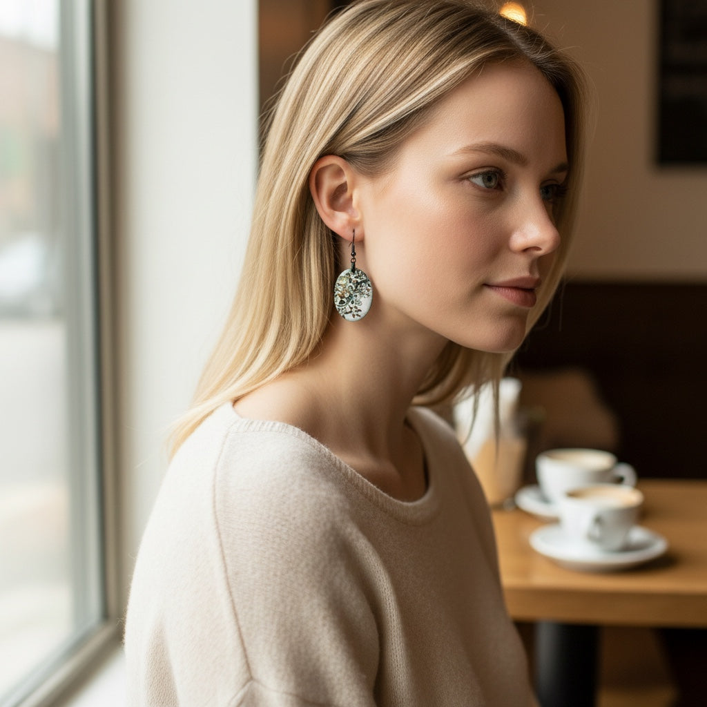 Bedrock Rose white oval copper earrings with black floral enamel art. Artisan handcrafted botanical design.