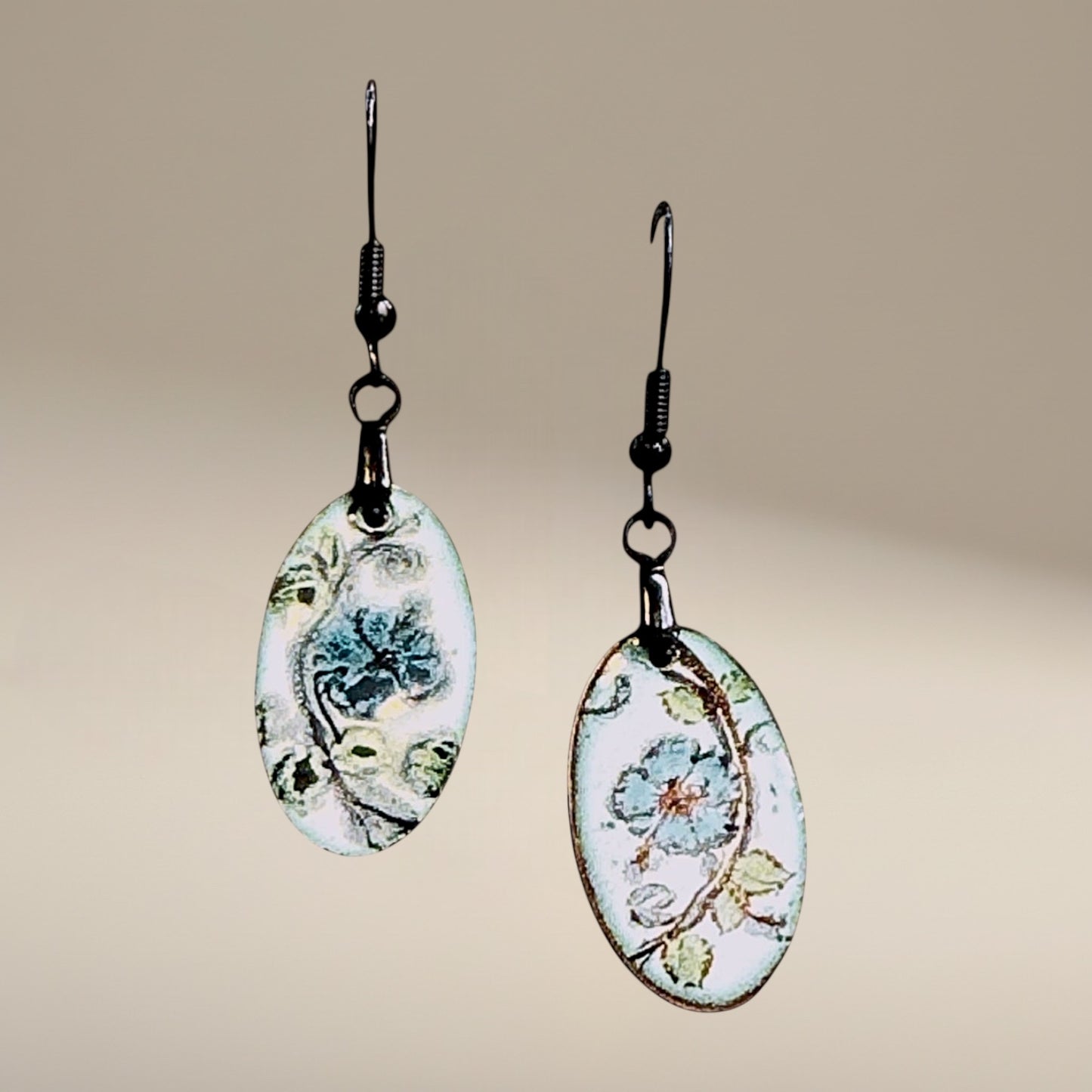 Bedrock Rose hand-painted oval dangle earrings with azure blue flowers and green leaves on white enamel.