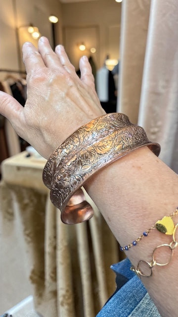 Bedrock Rose extra-large copper cuff bracelet with a double curve and intricate antiqued floral pattern on a wrist