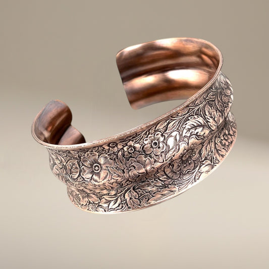 Bedrock Rose extra-large copper cuff bracelet with a double curve and detailed floral pattern in an antiqued finish.