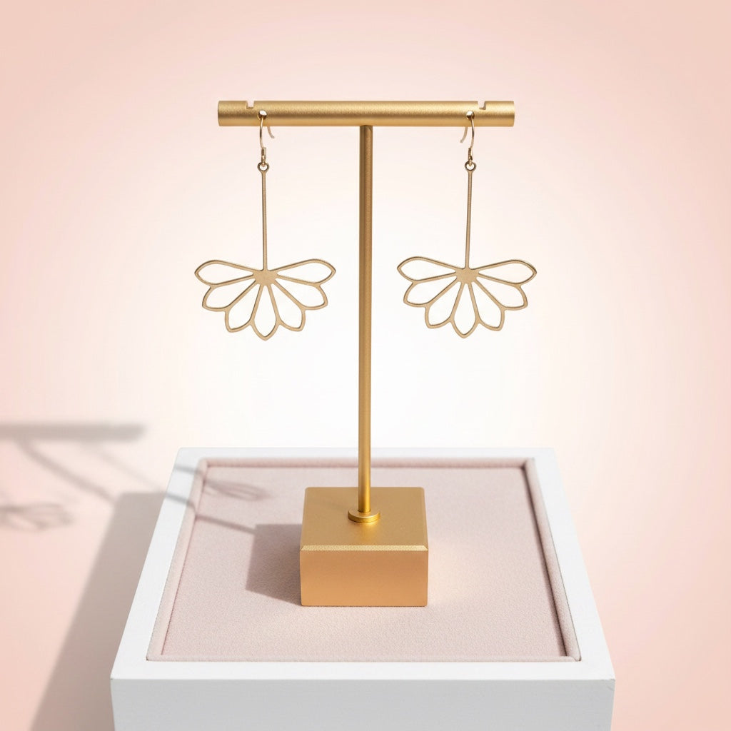 Bedrock Rose gold-plated brass drop earrings featuring geometric Art Deco flower petals on a jewelry display stand.
