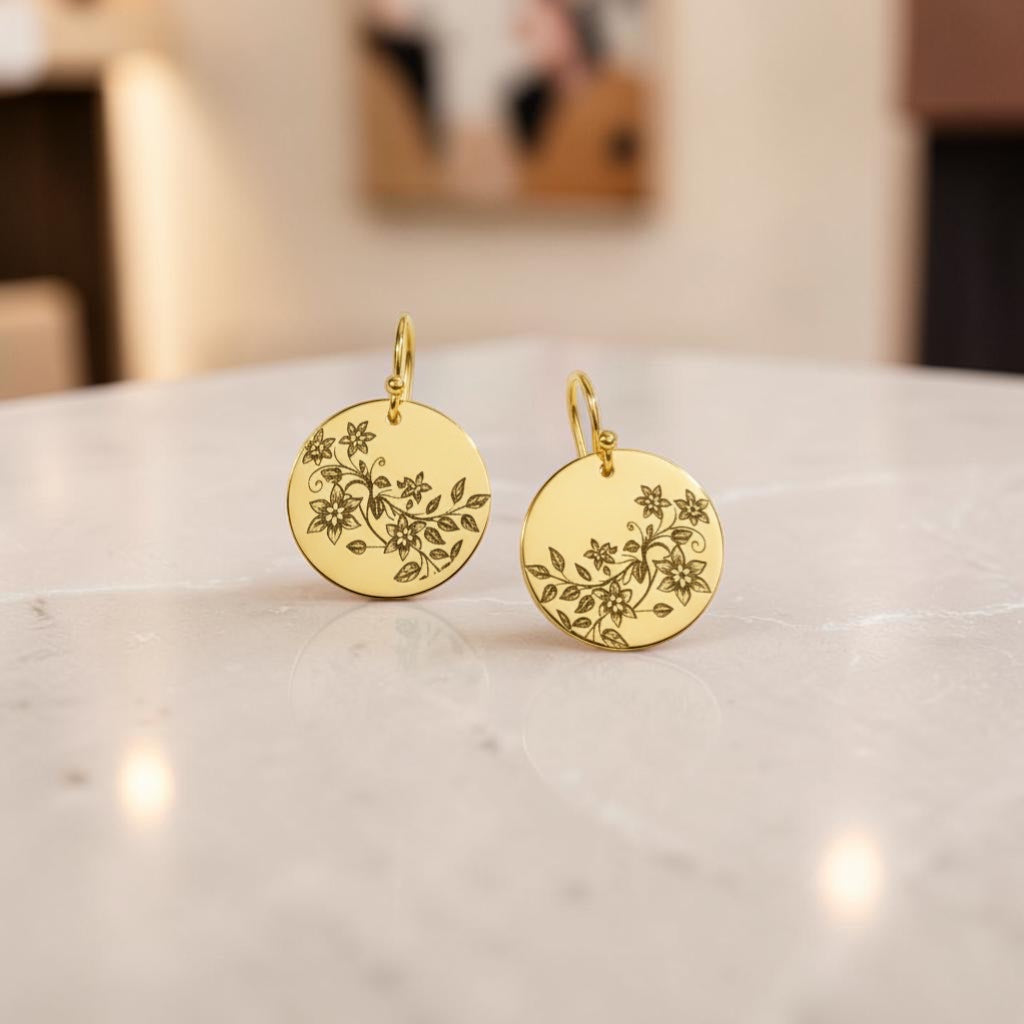 Bedrock Rose gold disc dangle earrings featuring delicate laser-engraved floral vine patterns on polished brass.