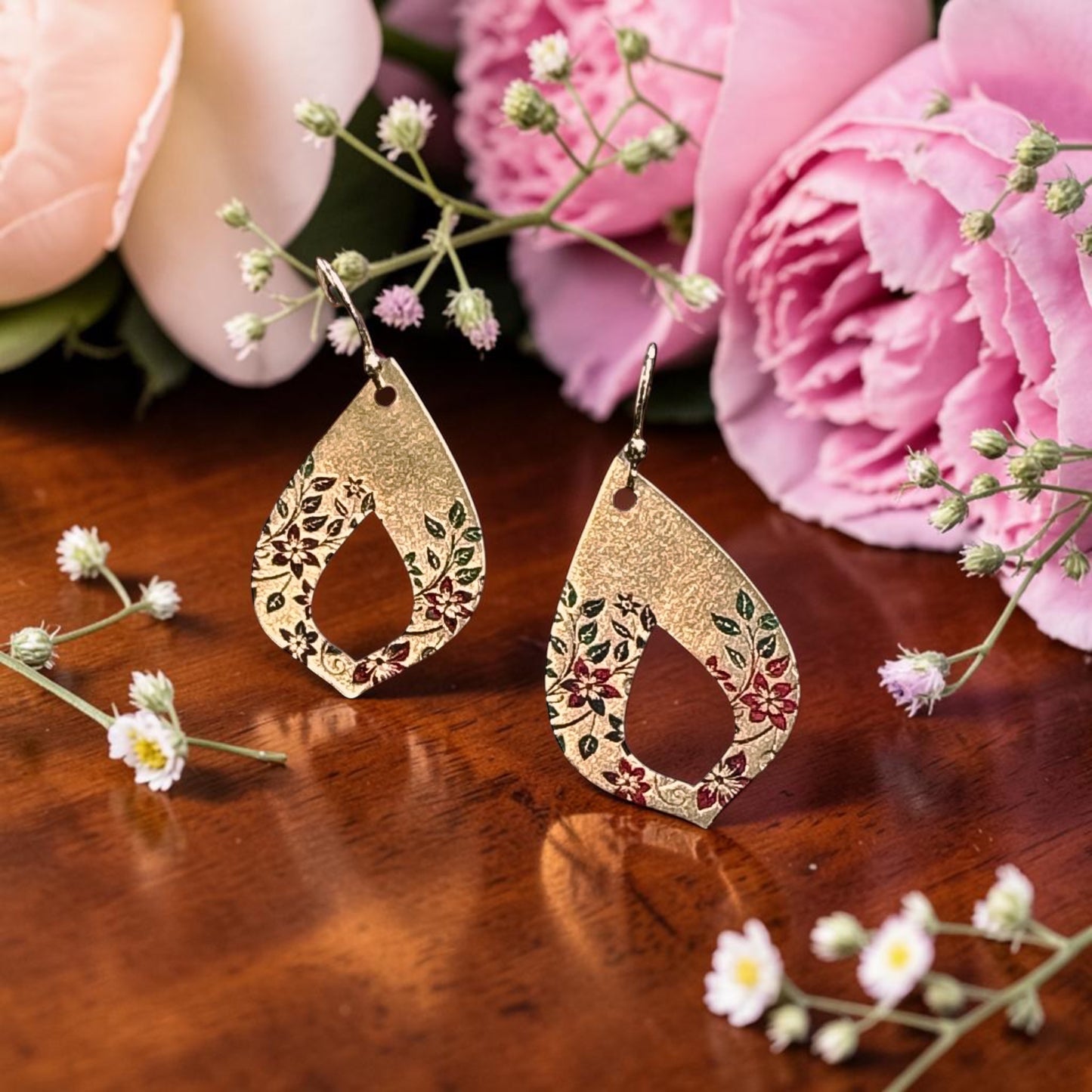 Bedrock Rose gold teardrop earrings with hand-painted crimson flowers and green leaves on an open floral vine design.