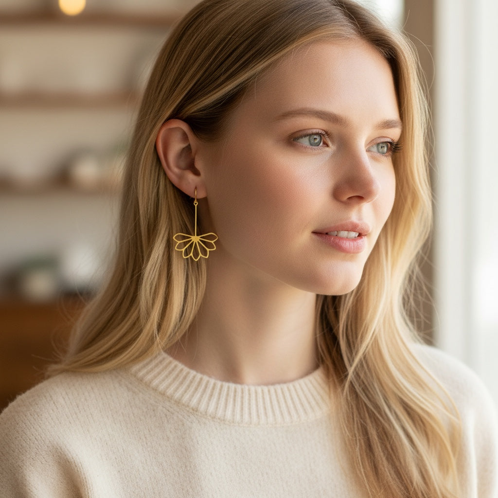 Bedrock Rose gold drop dangle earrings with laser-cut geometric flower petals worn by a blonde woman.