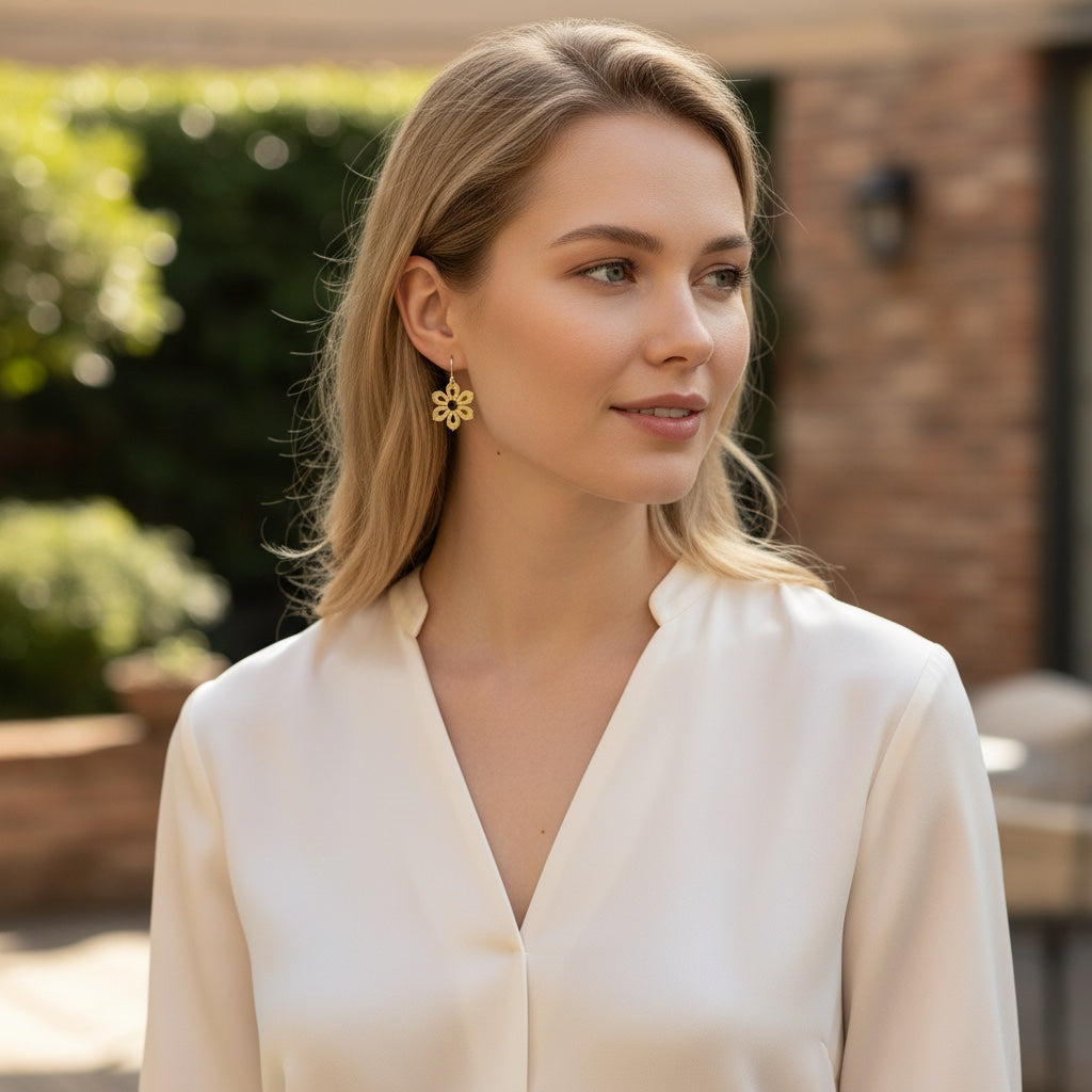 Bedrock Rose gold-plated brass Art Deco flower earrings worn by a woman in a white blouse.