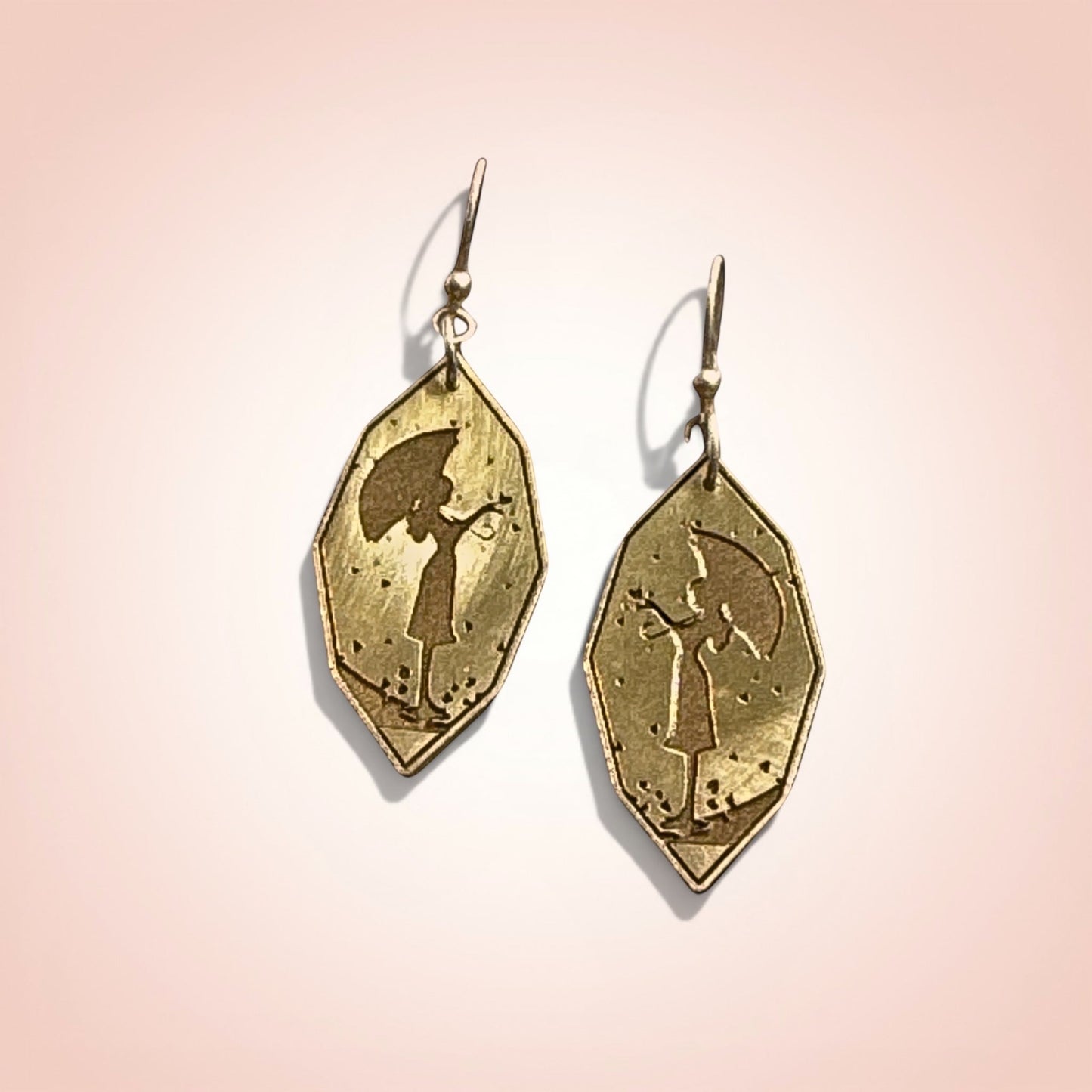 Bedrock Rose gold-plated drop earrings featuring a silhouette of a girl with an umbrella.