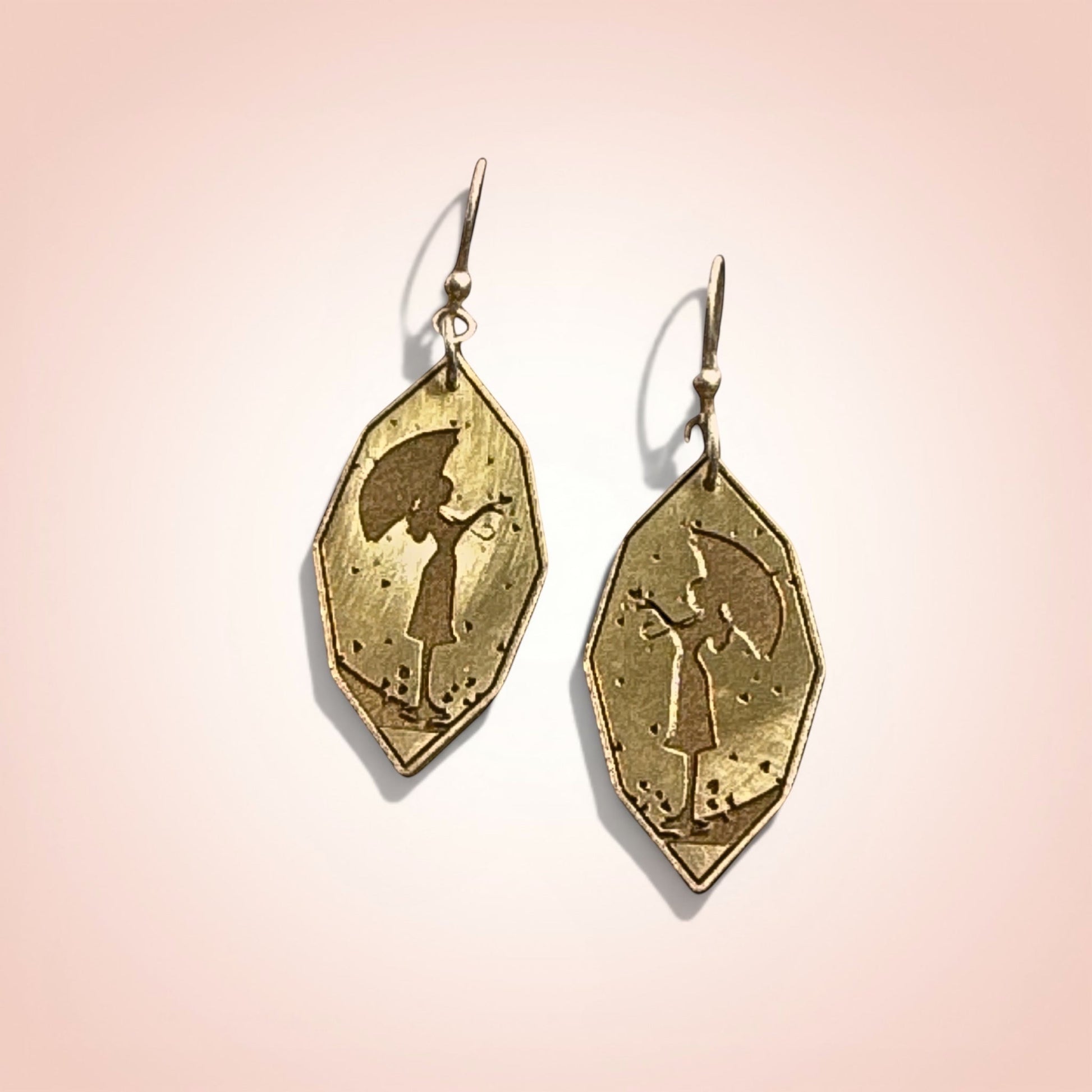Bedrock Rose gold-plated drop earrings featuring a silhouette of a girl with an umbrella.