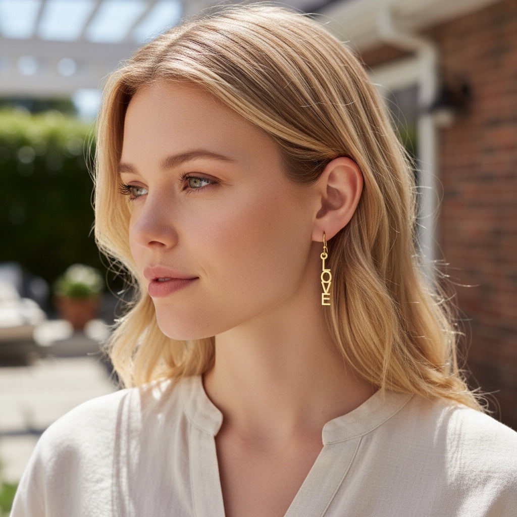 Bedrock Rose gold-plated dangling earrings with laser-cut out "Love" text. Surgical steel earwires.