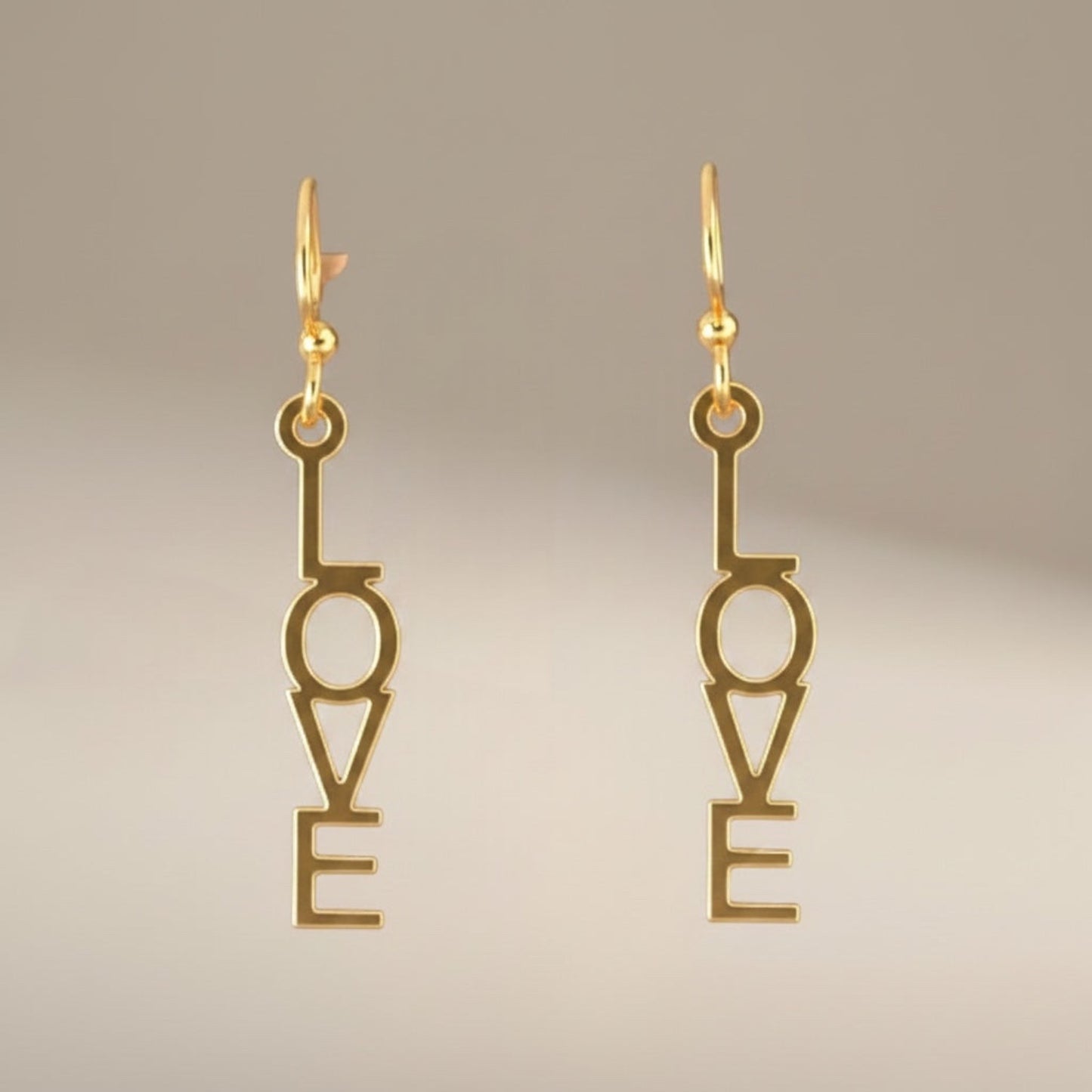Bedrock Rose gold-plated dangling earrings with laser-cut "Love" text, surgical steel earwires.