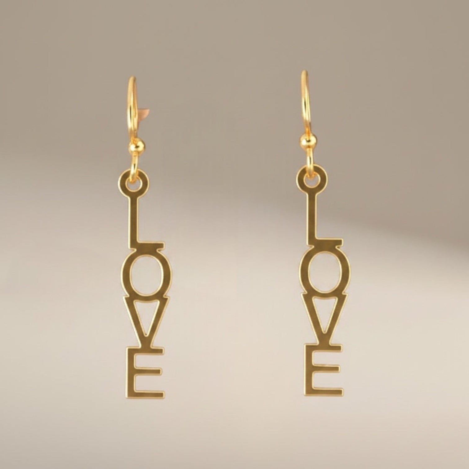 Bedrock Rose gold-plated dangling earrings with laser-cut "Love" text, surgical steel earwires.