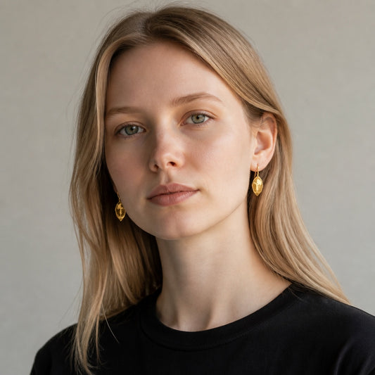 Bedrock Rose gold-tone earrings featuring a girl with an umbrella silhouette worn by a woman with blonde hair.