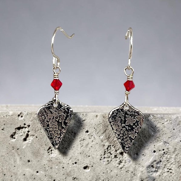 Bedrock Rose sterling silver dangle earrings with roll-printed grape vine pattern and ruby red crystal accents.