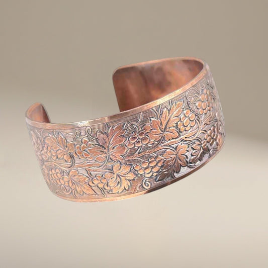 Bedrock Rose polished copper cuff bracelet featuring an ornate, detailed grapevine pattern with embossed leaves.