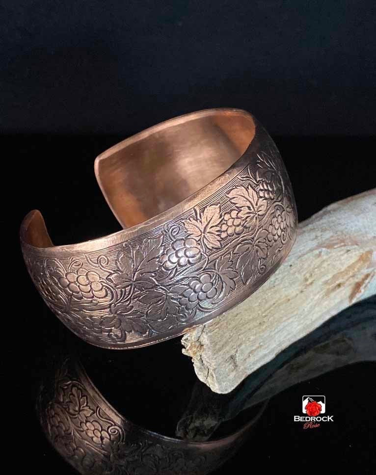 Bedrock Rose polished copper cuff bracelet featuring an ornate embossed grapevine pattern on a convex band.