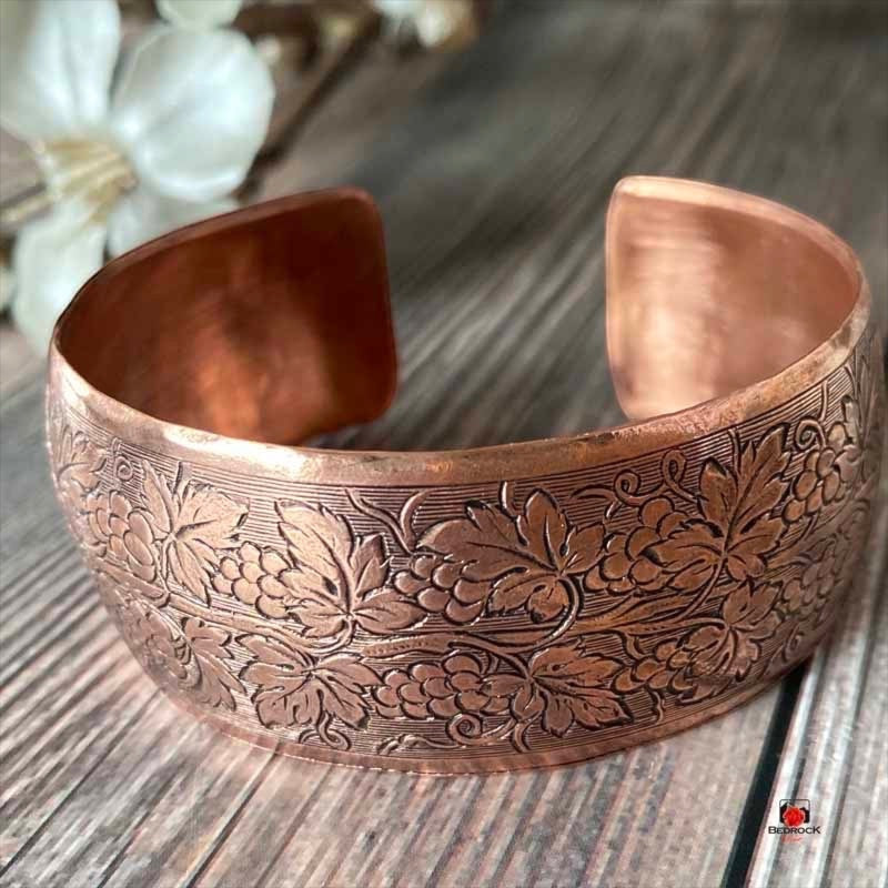 Bedrock Rose polished copper cuff bracelet featuring an ornate embossed grapevine and leaf pattern on a convex band.