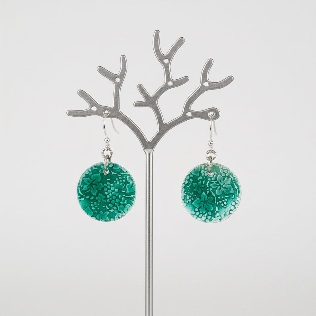 Bedrock Rose circular dangle earrings featuring a green transparent enamel grape and leaf motif on roll-printed silver.