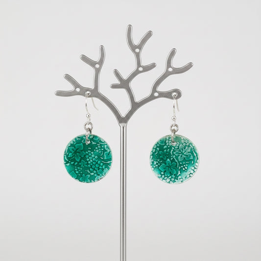 Bedrock Rose circular dangle earrings featuring a green transparent enamel grape and leaf motif on roll-printed silver.