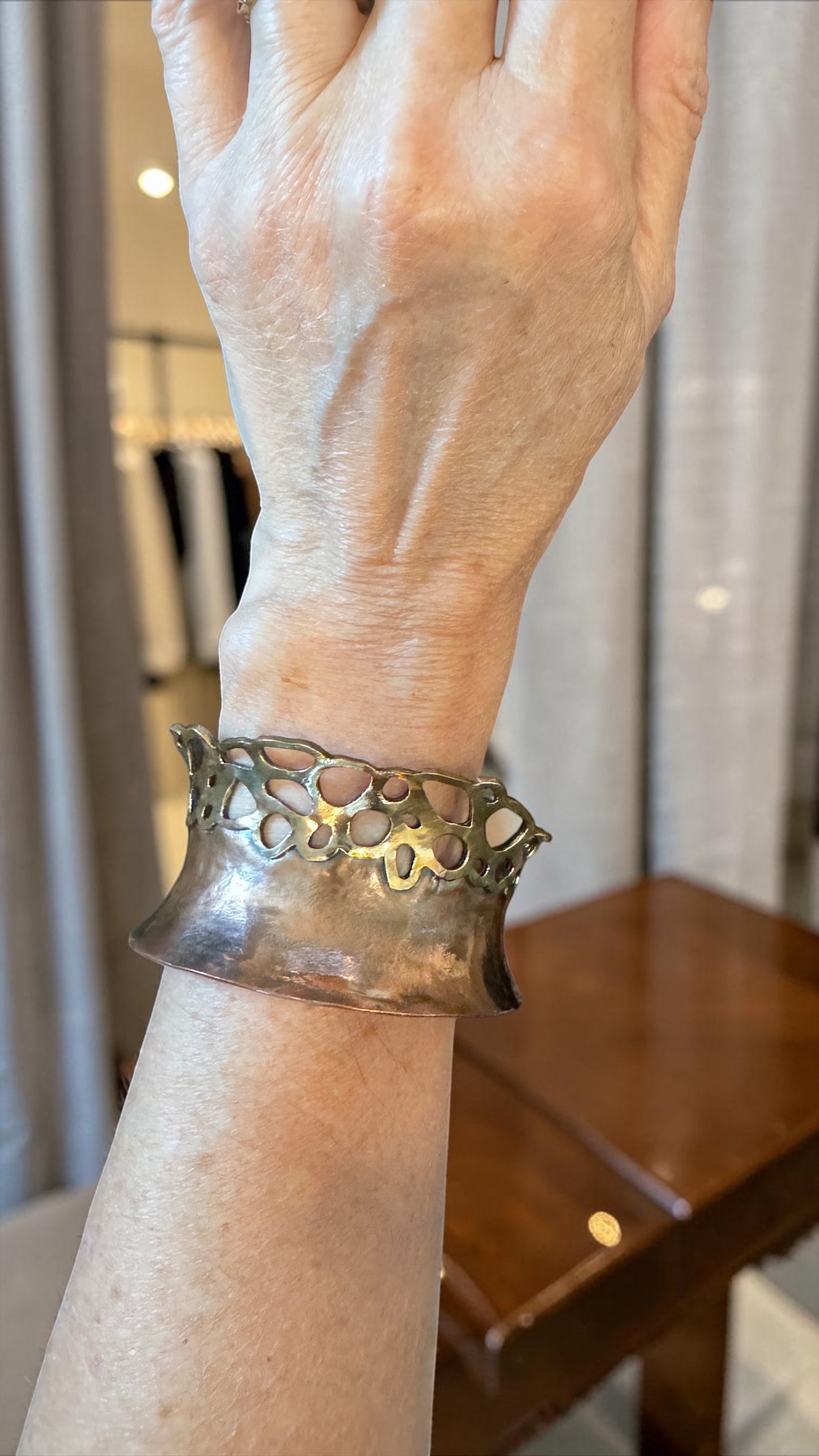Bedrock Rose lacy pierced copper and brass cuff bracelet worn on a wrist